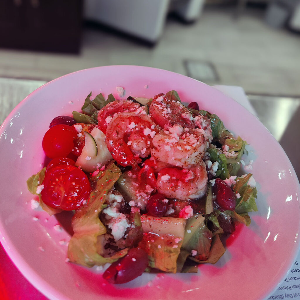 A fresh, chef-prepared seafood dish sits beside a red light, ready to be served.